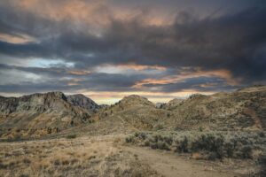 A dusty trail through sage covered hills